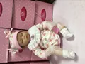 Detailed view of a sleeping reborn baby doll in floral outfit with NPK collection branding - Closed Eyes Floral Style / 40CM