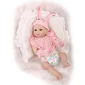 Realistic silicone reborn baby doll in pink rabbit hat lying on white lace pillow - Pink Rabbit Outfit Style / 55cm