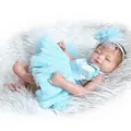 Detailed view of realistic baby doll in blue tutu dress on soft plush surface - Doll With Blue Dress And Headband / Blue