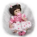 Close-up of lifelike baby doll with brown pigtails, lace dress and magnetic pacifier - 42cm Pink Floral Dress Style