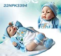 Muñeco Reborn con conjunto de punto azul, gorro y zapatos sobre alfombra blanca - Estilo Grande Recién Nacido / Azul Claro (22NPK3394)