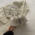 Elegant beige satin bucket bag with floral embroidery and white pearl drawstring - White