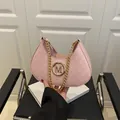 Roze halvemaanvormige okseltas met gouden ketting en reliëfstructuur met M-logo - Roze