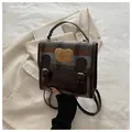 Détail du sac à dos à carreaux marron et bleu avec ours en peluche et lanières cuir - Marron