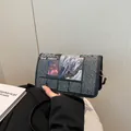 Black newspaper print crossbody bag featuring Red Abbles mountain art and metal hardware - Black