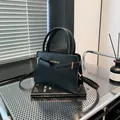 Classic black leather-style crossbody bag with golden hardware and top handles - Black