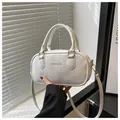 Detail of white mini crossbody bag with gold FASHION & BAGS logo and leather texture - White