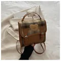 Détail d'un sac à dos vintage en tweed à carreaux et cuir avec écusson ours en peluche - Marron