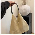 Detail der beige Strohtasche mit schwarzem Ledergriff und handgewebter Netzstruktur - Schwarz