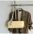 Detalle de bolso en cuero PU amarillo claro con lazo de perlas blancas y encaje - Con Colgante de Perlas y Encaje / Amarillo