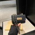 Mini borsa a tracolla nera intrecciata con catena dorata e chiusura a scatto metallica - Nero