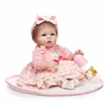 Realistische Reborn-Babypuppe im rosa Blumenkleid mit Fläschchen auf Plüschmatte - 42 cm