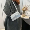 Silver candy color handbag with wave flap design and dual straps in a modern setting - Silver