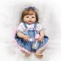 Realistic reborn baby doll in denim overall dress with a pink bow and bottle - Floral Dress Girl Style (1507) / 57cm