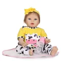 Realistic reborn baby doll in cow print outfit with nursing bottle and pacifier on a mat - Yellow / 55 cm