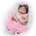 Realistic reborn baby doll in pink floral dress with bottle on white plush background - 56cm Girl Doll / Pink Floral Style