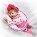 Realistic reborn baby doll in pink elephant outfit on white faux fur background - Pink Floral Outfit Style / 55 cm