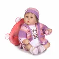 Realistic reborn doll in pink knitted outfit with pacifier on a plush pillow - Simulated Baby (1619) / Pink Purple / 40 cm