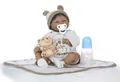 Detailed view of lifelike black newborn doll with baby bottle and plush bear accessory - Blue