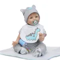 Detailed view of reborn baby doll with dinosaur bib, knit hat, bottle and pacifier - Open Eyes Style