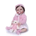 Realistic reborn baby doll in pink knit outfit with plush bear and pacifier - White
