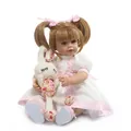 Realistic silicone reborn doll in pink princess dress holding a white plush bunny toy - Pink