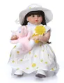 Dettaglio di una bambola reborn realistica con vestito a pois e piccolo elefante di peluche - Bianco / 70 cm