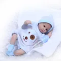 Detailansicht der Reborn-Babypuppe im blau gestreiften Outfit mit Flasche auf Plüsch - Blau