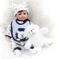Reborn baby boy doll in blue lion outfit sitting with white plush teddy bear - Blue