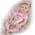 Lifelike baby doll in pink floral dress and headband on soft white plush background - Pink / 55cm
