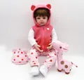 Dettaglio della bambola reborn con gilet rosa e peluche a forma di giraffa incluso - Rosa