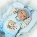 Nahaufnahme einer lebensechten Reborn-Babypuppe mit blauer Mütze und Bären-Lätzchen - 55 cm / Blau