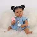 African American reborn baby doll with blue eyes and denim dress on white faux fur - Dark Brown Skin with Heart Necklace (Style 2)