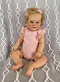 Realistic 60cm reborn toddler doll wearing a pink ruffled romper and floral headband - Cloth Body (Fifty Centimeter) / Gold