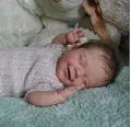 22-inch silicone reborn baby doll in pink knit romper smiling on a plush green blanket - Exquisite Painting 4(2005) / 55cm Silicone Body Boy