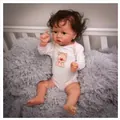 Lifelike 22-inch reborn doll with curly brown hair in a cat-print romper on a plush rug - Full Silicone Girl Style / Exquisite Cartoon Painted Style
