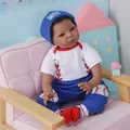 Bambola neonato nero realistica da 55 cm in abito da baseball seduta su un divano rosa - Stile Baseball Pelle Nera / 55 cm