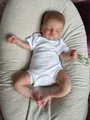 Realistic 48cm Rosalie reborn doll in white bodysuit sleeping on a floral pillow - Figure 1 / 48cm