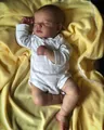 Detailed close-up of a 19 inch lifelike reborn sleeping baby doll in white romper - 49cm Cloth Body / Exquisite Painted Doll