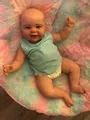 Close-up of realistic newborn baby doll in blue top on colorful plush fabric - As Shown / 60 cm