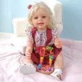 Bambola Yannik realistica da 55 cm con pelle 3D e vestito floreale con gioco in legno - Bambola Neonata di Simulazione / 55 cm