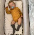 Reborn baby doll Liam wearing yellow waffle romper and grey socks with pacifier - Turmeric / 50 cm