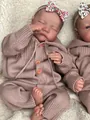 Close-up of reborn baby doll sleeping in pink knit romper with floral headband - Closed Eyes / 46cm Cloth Body