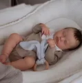 Lifelike 19-inch Reborn LouLou baby doll in beige romper sleeping in a white waffle nest - 49cm / Full Vinyl Girl Version