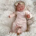 Realistic 19 inch reborn baby doll sleeping in pink floral outfit on soft white plush - Cloth Body Style