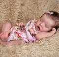 Macro detail of a sleeping newborn reborn doll in floral pink outfit on plush blanket - Cloth Body Style / 49cm