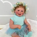 50cm Harper reborn doll with blue knit outfit and flower headband on white rug - Cloth Body Doll / 50 cm
