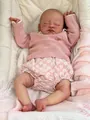 Detailansicht der Reborn-Babypuppe August in rosa Strickpullover und Blumenshorts - Stoffkörper-Stil / 19 Zoll
