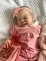 Detail einer 19-Zoll Reborn-Puppe mit rosa Kleid, Schnuffeltuch und Geburtsurkunde - Stoffkörper-Stil