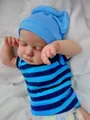 Close-up of sleeping reborn baby doll skin textures and realistic knit outfit details - Blue Striped Clothing / Full Vinyl Body